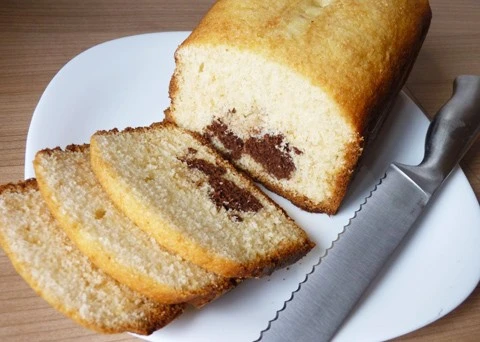 Náplňová bábovka s čokoládovým středem na bílém talíři.