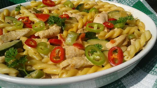 Pasta s kuřecím masem, paprikou a okurkou v bílé misce.