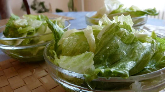 Skleněné misky s čerstvým listovým salátem připravené pro recept na ledový salát.