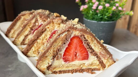 Slojeité dorty s jahodami a mascarpone na bílém talíři.