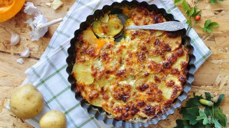 Zapečené brambory v pekáči s zlatou kůrou.