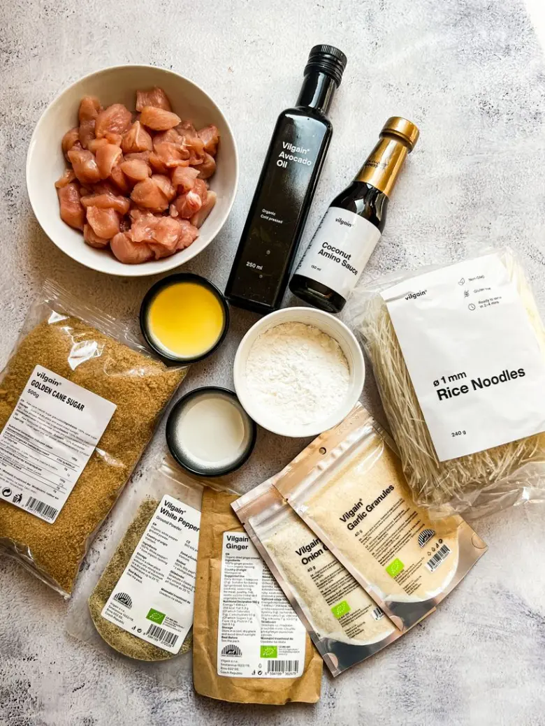 Suroviny pro recept s rýžovými nudlemi, masem a kořením.