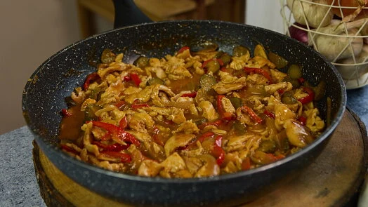Hot chicken stew with peppers in frying pan ready to serve.