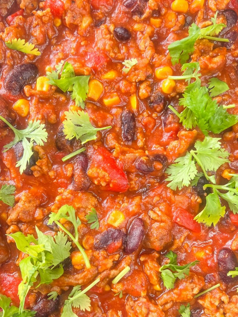 Chilli s mletým masem a fazolemi ozdobené koriandrem.