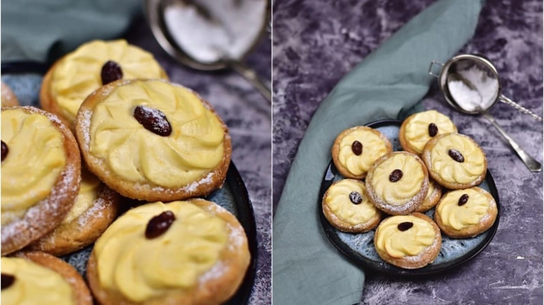 Zlatohnědé nekynuté svatební koláčky s marmeládou a rozinkami posypané moučkovým cukrem.