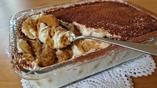 Hotový tiramisu v skleněné míse s lžící.