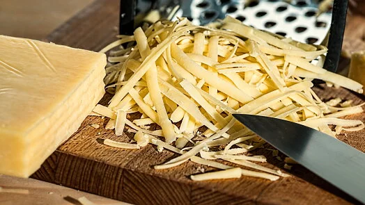 Nařezaný tvrdý sýr připravený pro recept na sýrové smaženky.