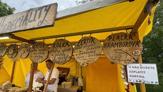 Stánek s lívancemi a cedulemi v češtině na trhu.